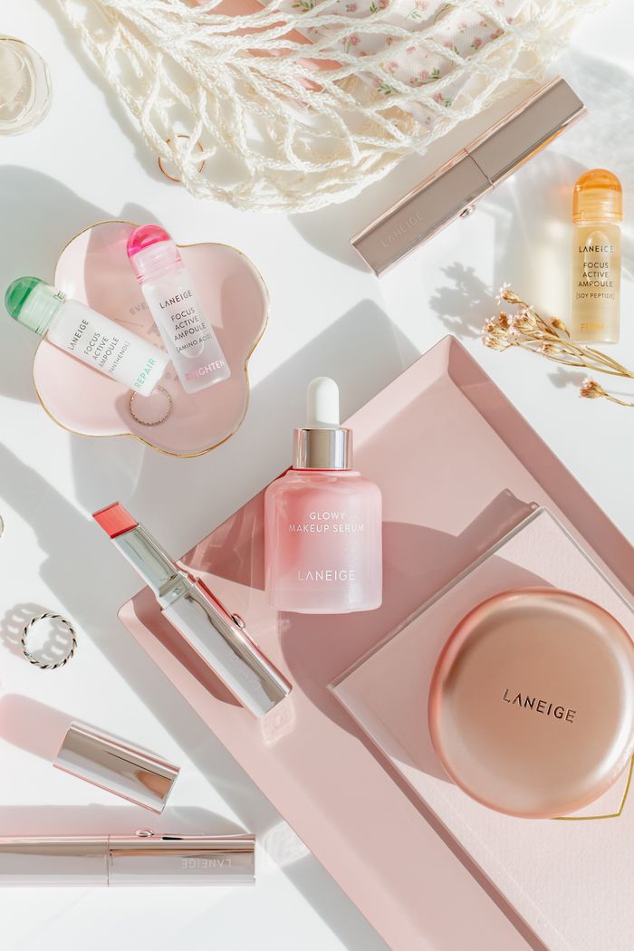 hero-img-02 Stylish flat lay of Laneige skincare and makeup items on a pastel surface.